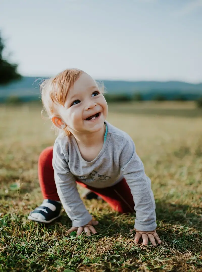 selective focus photo of baby crawling on grass